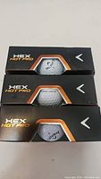Stack of three unopened Callaway HEX Hot Pro golf ball packs, packaging shows the branding and a portion of the golf balls inside.