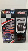 Box showing NASCAR branding and coffee maker image with racing cars graphic and product features on front.