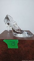 Side view of the clear glass slipper showing pointed toe and curved heel
