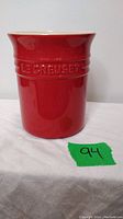 Front view of the red Le Creuset utensil holder showing embossed branding.
