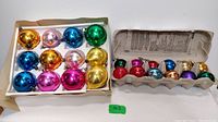 Photo showing 12 vintage glass balls in a box and 12 vintage glass balls in an egg carton, displaying variety of colors and finishes