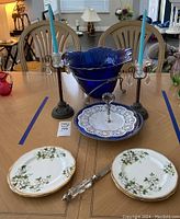 Overview photo showing all items on table including bowl, candle sticks, serving stand, plates, and candle snuffer.
