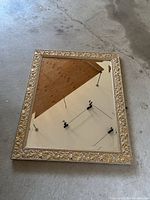 Full view of rectangular mirror showing entire frame and reflective surface on a concrete floor.