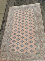 Full view of rug laid flat on pavement showing overall design, pattern, and condition