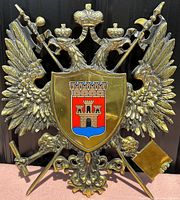Front view of vintage cast metal coat of arms plaque showing detailed double-headed eagle with shield displaying Toledo emblem.