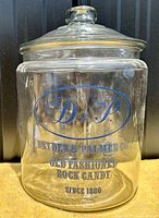 Front view of large clear glass jar with blue vintage Dryden & Palmer rock candy text.