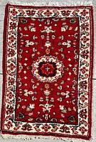 Full view of the vintage Persian carpet showing central medallion and border design on a vibrant red wool background.