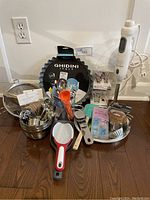 Entire baking set arranged showing flan pan, mixing bowls, utensils, measuring cups and hand blender