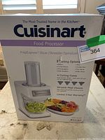 Front view of box showing Cuisinart branding and food processor image with cutting options and cones.