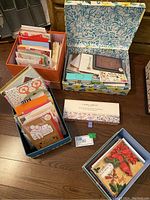 Overview of four storage boxes filled with assorted greeting cards and note cards.