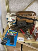 Shelf display of various garage items including Minwax cleaner, Can-Gun, jack, ropes, and opener tool.