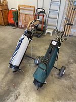 Two golf bags with clubs on pull carts, showing overall lot contents