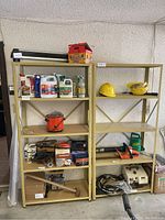 Front view of both metal shelves filled with various garage and household items to show shelving structure and condition.