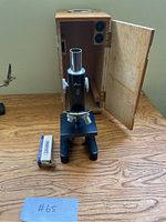 AmScope compound microscope placed in front of open wooden holder case, box of coated slides nearby.