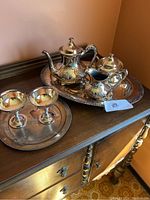 Overall view of large tea service and small tray with goblets on sideboard