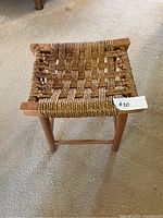 Top-down view of the small woven rope and wood stool showing the woven rope seat in a basket weave pattern and wooden frame.