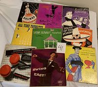 Top down photo showing 10 vintage 10 inch record sleeves with colorful themed covers including jazz, swing, Latin, and operatic music.