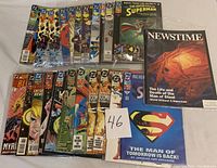 Top view of 23 superhero comic books including editions of The Adventures of Superman with foil cover variant #82 and other titles like Newstime, showing bagged condition and excellent preservation.