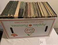 Long shot of large box filled with around 100 records in various condition with visibly worn sleeves