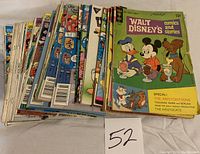 Photo showing a stack of comic books including Walt Disney's Comics and Stories with Mickey Mouse, Donald Duck, and Pluto on cover