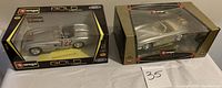 Two boxed Bburago 1:18 scale model cars side by side showing front and top view of packaging.