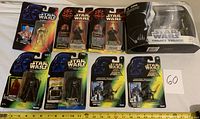 Photo showing all ten Star Wars action figures, new in packages, including several Darth Vader figures and one boxed collection pack.