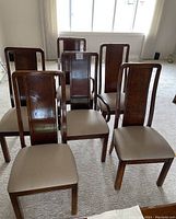 Six wooden dining room chairs arranged in two rows, showing front view and overall condition.
