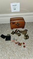 Overview photo of all items including wooden chest, Chinese coins, variety of pins, and Zippo lighter