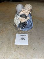 Front view of the Royal Copenhagen figurine showing two children hugging a black dog