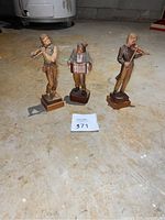 Three wood carved musician figurines together showing full set and scale.