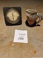 Photo showing the temperature and humidity indicator device and the Doulton Colimbeo creamer dish on a floor surface.