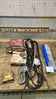 Top view of various tools including Weller soldering iron in box, stapler, work light, and a box of staples.