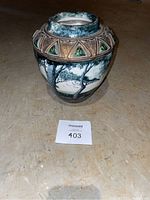 Front angle showing detailed painted trees and birds design with geometric border on rim.