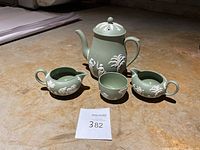 Full set of Wedgwood jasperware tea items: teapot, two creamers, sugar dish on stone floor.