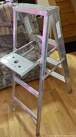 Side angle of foldable aluminum step ladder showing wide platform, steps, and structure