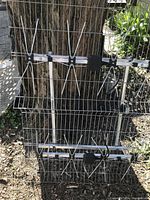 4-bay analog TV antenna with metal directional elements and grid reflector attached to a fence outdoors.