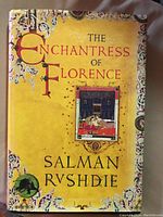 Front cover of 'The Enchantress of Florence' showing ornate yellow medieval-style design with title and author name.
