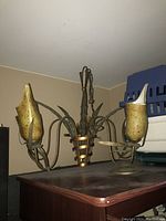 Full view of the vintage Firenze chandelier with 5 lamps showing the metal frame and yellowish glass lamp curves.