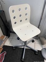 Front view of white IKEA JULES swivel desk chair showing seat and backrest with circular holes.
