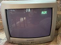 Front view of vintage 13-inch Cathode Ray CRT television displaying AUX input active on screen.