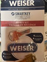 Image of front side of Weiser SmartKey Re-Key Kit packaging showing the keys inside and branding
