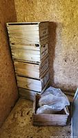Stack of five wooden apple boxes with open tops in a shed corner