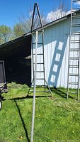 Full view showing the tall A-frame structure of the magnesium ladder with a narrow pointed top and wide base.