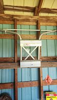 Full frontal view of the Sta Safe ladder stabilizer mounted on wooden beams within a barn or shed environment.