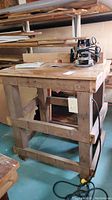 Full side and front view of homemade wooden router table with router placed on top showing overall condition and construction