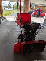 Front view showing red vinyl shield attachment over control area and steel auger housing.