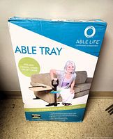 Front view of Able Life Able Tray box showing product name, features, and image of the tray attached to a couch with a person using the safety handle.