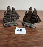 Pair of antique cast iron flying cloud sailing ship bookends side by side showing full detail and patina.
