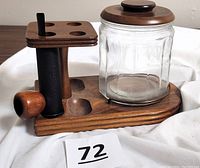 Full view of the wooden Aztec pipe holder with 4 pipe slots and glass humidor jar with wooden lid, showing one pipe in holder