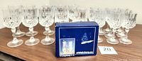 26 Cristal d'Arques lead crystal glasses arranged on table with original blue box of 6 cordial glasses